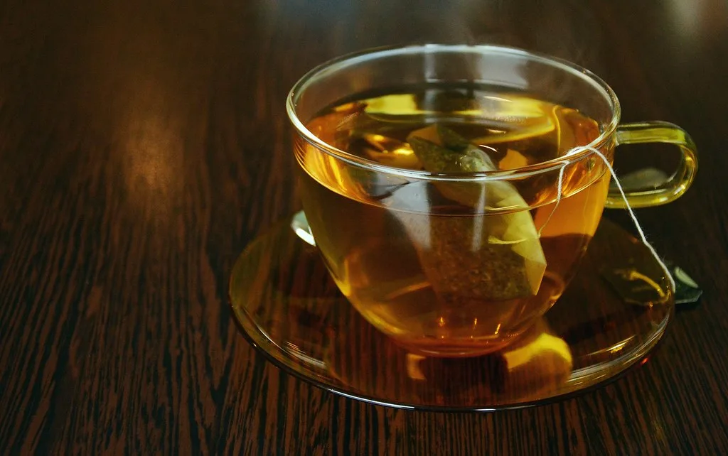 Tea bag steeping in a glass cup of hot water